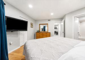 a bedroom with a large bed and a flat screen tv at 3697 Orlando Vacational Apartment in Orlando