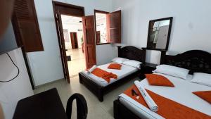 ein Zimmer mit zwei Betten und einem Stuhl in der Unterkunft Hotel Marios in Espinal