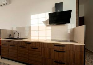 a kitchen with a sink and a tv on the wall at Welcome Hostel in Churriana