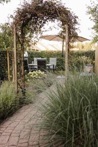 ein Garten mit einem Bogen, an dem ein Tisch und Stühlen befestigt sind in der Unterkunft Schöne Lage in Lage