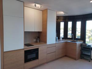 a kitchen with wooden cabinets and a sink at Rosa de los Vientos 71 Renovado julio 2026 in Mijas Costa