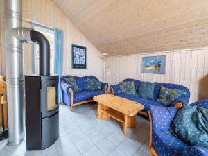 a living room with blue couches and a wood stove at Gemütliches Ferienhaus im skandinavischen Stil in Granzow
