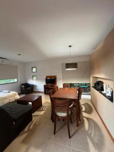 a living room with a dining table and a living room with a bed at Complejo Totoras in Pinamar