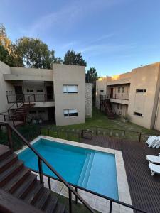 a swimming pool in front of a building at Complejo Totoras in Pinamar