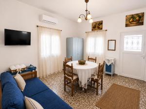 a living room with a blue couch and a table at Rou Garden House in Karpathos