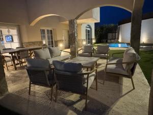a patio with chairs and a table and a pool at Villa entre Viñas in Lavid