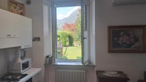 a kitchen with a window with a view of a garden at B&B MAST Apartment Suite in San Pellegrino Terme
