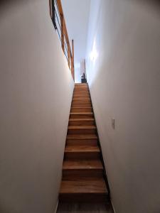 a staircase in a white room with wooden floors at Aires de la costa Renovado in Neuquén
