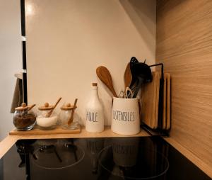 a shelf with kitchen utensils and bottles on it at Sweet Home & Spa in Erstein +6 photos