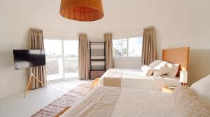 a bedroom with two beds and a flat screen tv at Casa Sofia 19 Guests, Steps From The Sea in Tela +37 photos