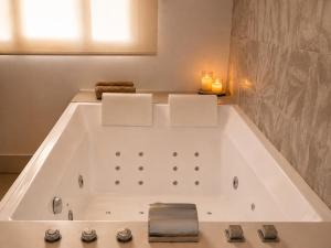 a bathroom with a tub with two candles in it at Sweet Home & Spa in Erstein