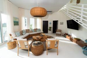 a living room with a couch and a table and chairs at Casa Sofia 19 Guests, Steps From The Sea in Tela