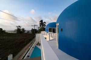a blue building with a view of a swimming pool at Casa Sofia 19 Guests, Steps From The Sea in Tela