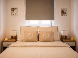 a bedroom with a bed with two pillows and a window at Sweet Home & Spa in Erstein