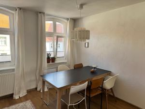 a dining room with a black table and chairs at Wohnen am Prenzlauer Tor in Pasewalk
