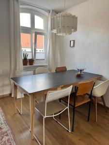 a dining room table with white chairs and a black table at Wohnen am Prenzlauer Tor in Pasewalk +3 photos
