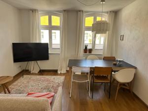 a living room with a dining room table and a television at Wohnen am Prenzlauer Tor in Pasewalk