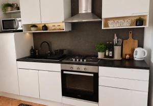 a kitchen with white cabinets and a stove top oven at Holiday House Pulina in Punat
