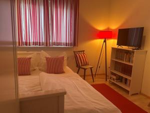 a bedroom with a bed and a television and a chair at Petite Bellevue II in Baden-Baden