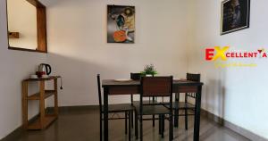 a dining room with a wooden table and chairs at Appart meublé Excellentia Edea in Edéa