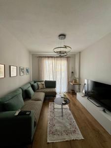 a living room with a green couch and a television at Erli's Apartment in Golem
