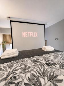 a netflix screen in a room with a bed at ZONA NAVIGLI Design Loft , Proiettore schermo 80" in Milan
