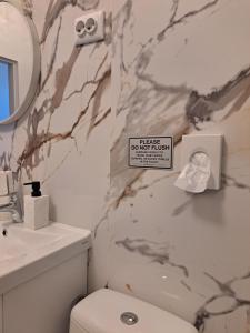 a bathroom with a toilet and a sink and a mirror at Peron 4-City & Station Stay in Rijeka +32 photos