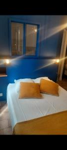 a blue bedroom with a bed with two pillows at Le Garage, La Chambre in Fontevraud-l'Abbaye