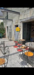 a group of tables and chairs in front of a building at Le Garage, La Chambre in Fontevraud-l'Abbaye +1 photo