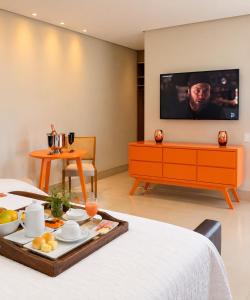 a hotel room with a tray of food on a bed at Hotel Imperador in Gurupi