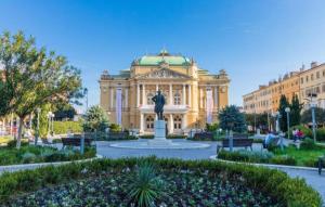 a building with a statue in front of it at Peron 4-City & Station Stay in Rijeka