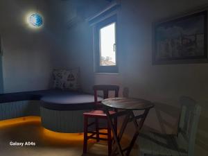a room with a bed and two stools and a window at Miji Stay in Fethiye