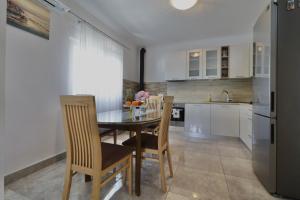 a kitchen with a table and chairs and a refrigerator at Amaryllis in Rogoznica