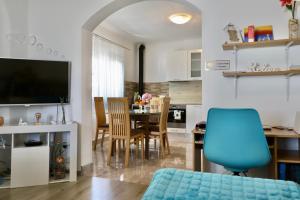 a living room with a table and a blue chair at Amaryllis in Rogoznica