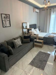 a living room with a couch and a bed at Greysuites in Kavála