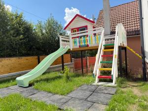 a playground with a slide and a play house at Austrian Villa's in Covasna