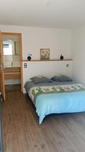 a bed sitting in a room with a mirror at Chambre chez sylvie in Laruns