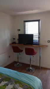 a bedroom with a desk with two chairs and a computer at Chambre chez sylvie in Laruns