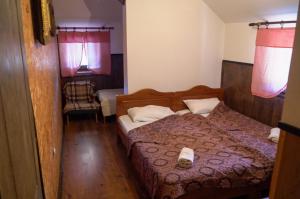 a small bedroom with a bed and a chair at Etno Resort Lipa 