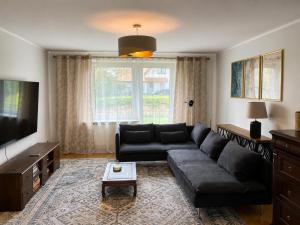 a living room with a couch and a tv at Nine to Trail Apartment in Wielka Wieś