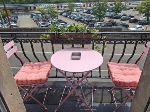 a pink table and two chairs on a balcony at La Vie en Rose in Verviers