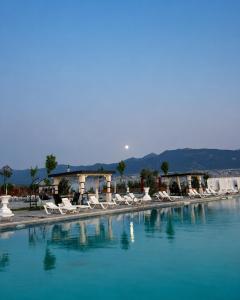 a group of white chairs sitting next to a swimming pool at Hipodrum Kompleks in Suharekë