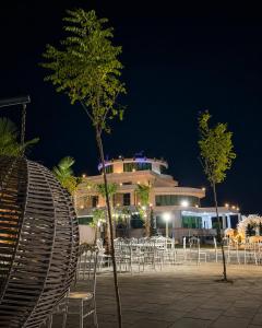 a building with chairs and tables at night at Hipodrum Kompleks in Suharekë +2 photos