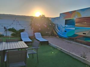 a patio with tables and chairs and a mural at Villa 16 personnes à 50m plage Sud in Lacanau