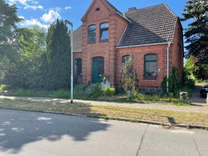 a red brick house on the side of a street at Zimmervermietung Tramm  +2 photos