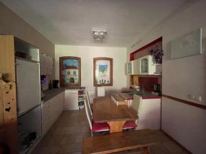 a small kitchen with a table and a refrigerator at Zimmervermietung Tramm 
