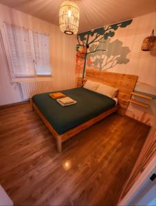 a bedroom with a bed and a tree mural on the wall at Villa 16 personnes à 50m plage Sud in Lacanau +24 photos