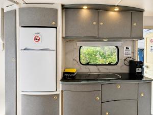 eine Küche mit Kühlschrank und Spüle in einem Wohnmobil in der Unterkunft Quinta Lima in Sertã