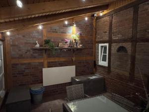 a room with a brick wall with a bench and a shelf at Kramerhof in Groß Fredenbeck