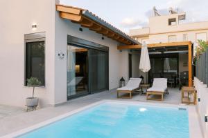 a swimming pool in the backyard of a house at Odysseas Seaside Escape by Philoxenia in Artemida